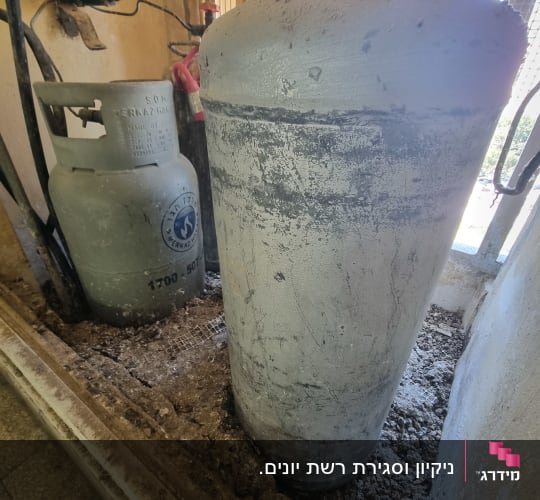 הצטברות עבה של צואת יונים סביב בלוני גז במסתור שירות